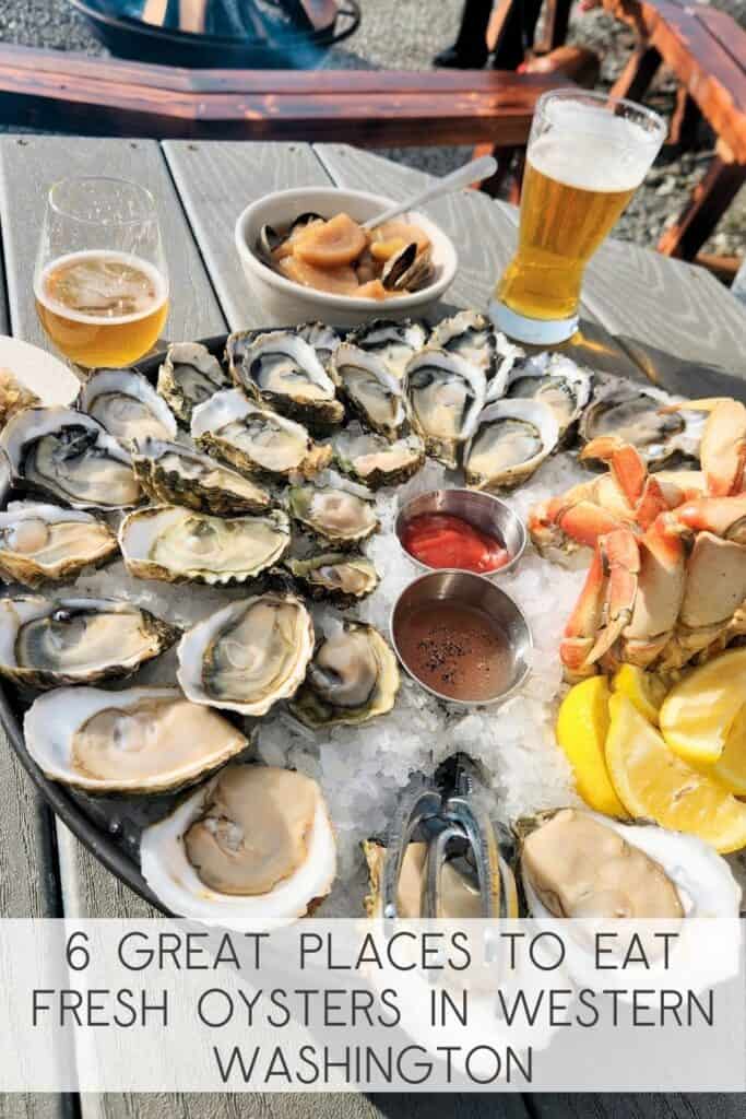 Fresh oyster platter with crab, mussels, lemon wedges, and drinks at a seafood restaurant in Western Washington.