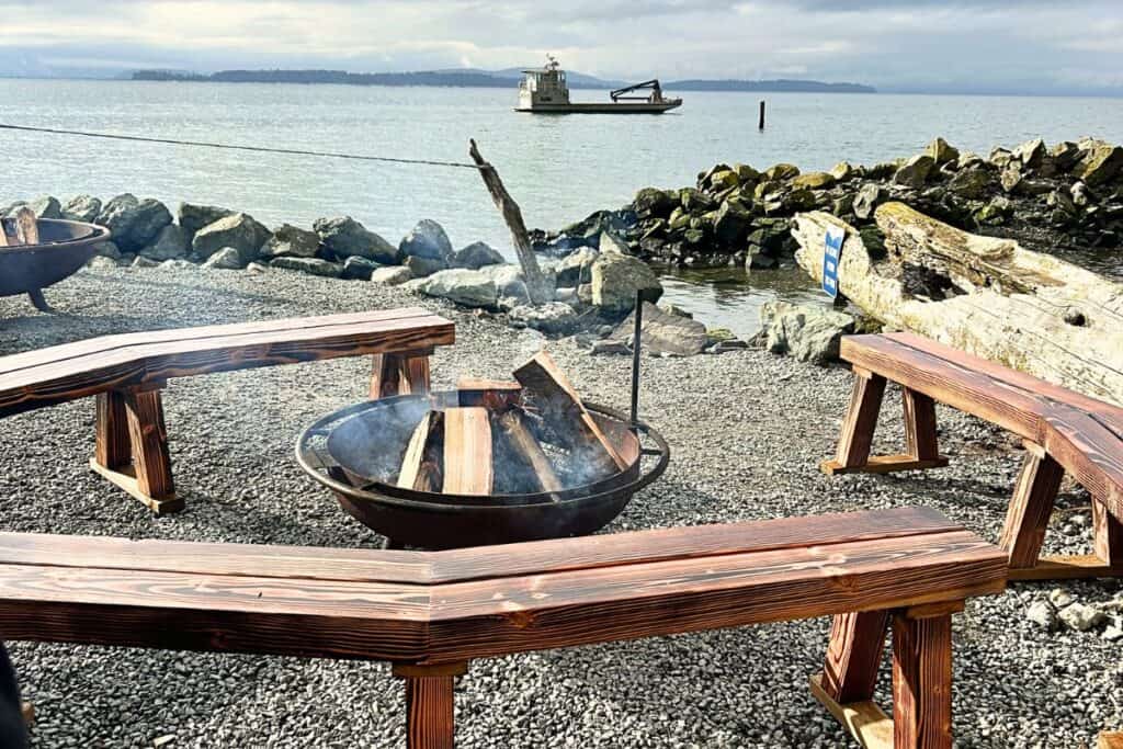 A fire pit and surrounding benches looking out at the oyster farm on Samish Bay in Bellingham, Washington. Taylor Shellfish Farms Oyster Bar