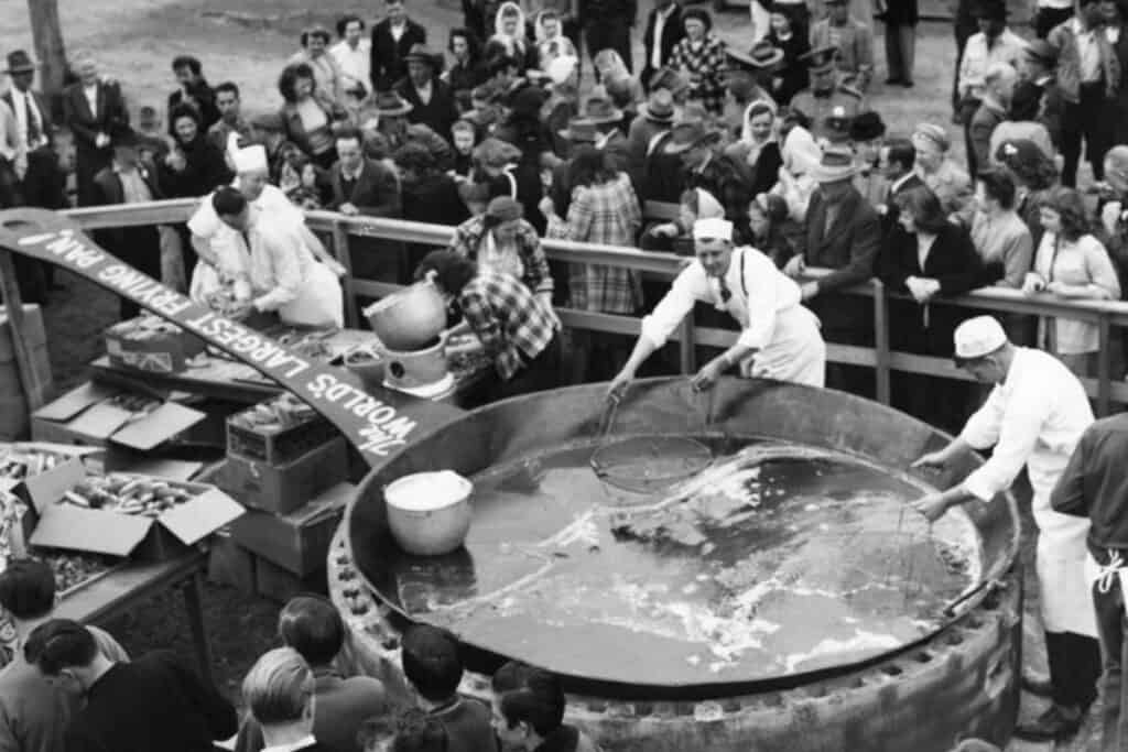 Historic photo of an annual clam festival at Long Beach, Washington, showcasing a 14-foot cast-iron frying pan.