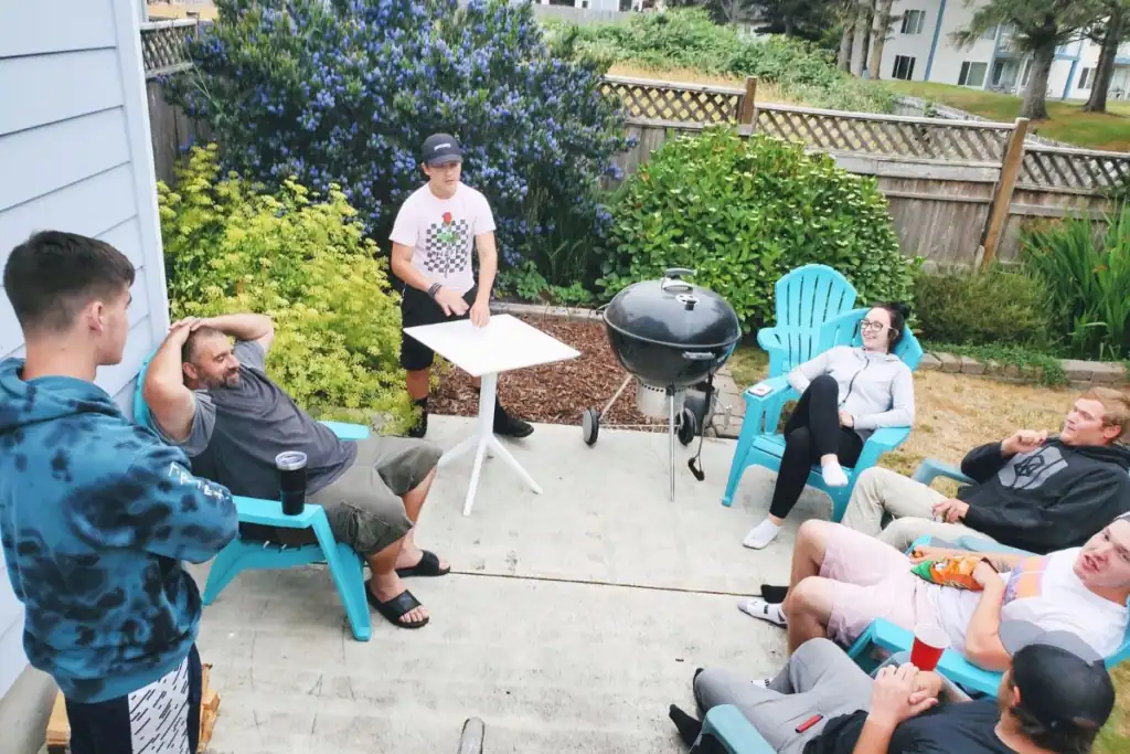 Family and adult children relaxing together outside a vacation rental in Long Beach, Washington