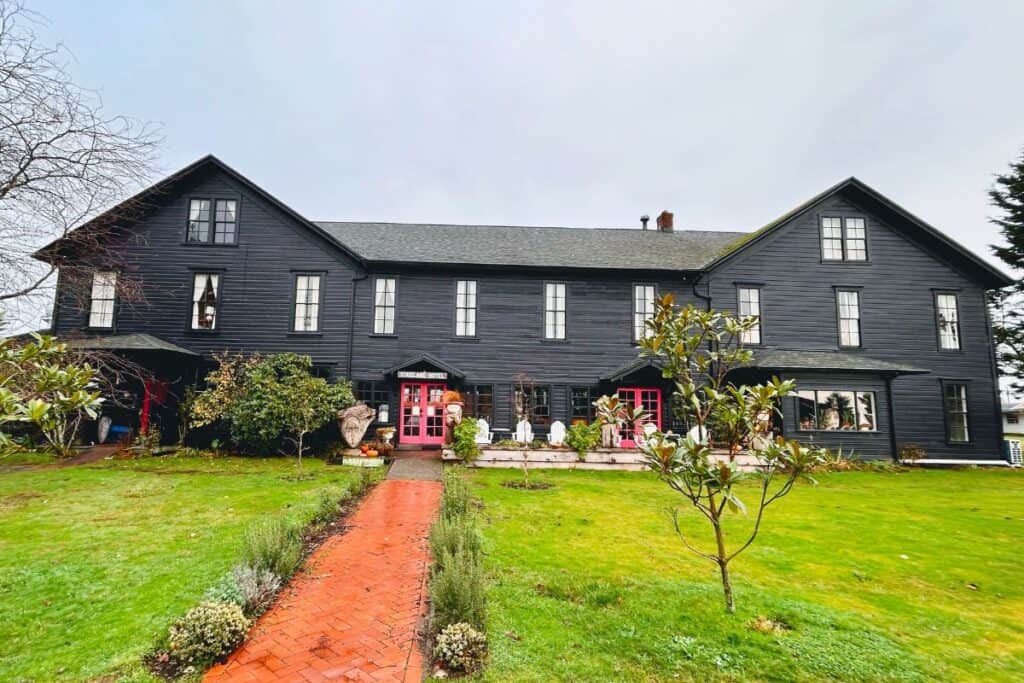 Tokeland Hotel in Tokeland Washington with dark exterior and red doors, one of the oldest hotels on the Washington Coast