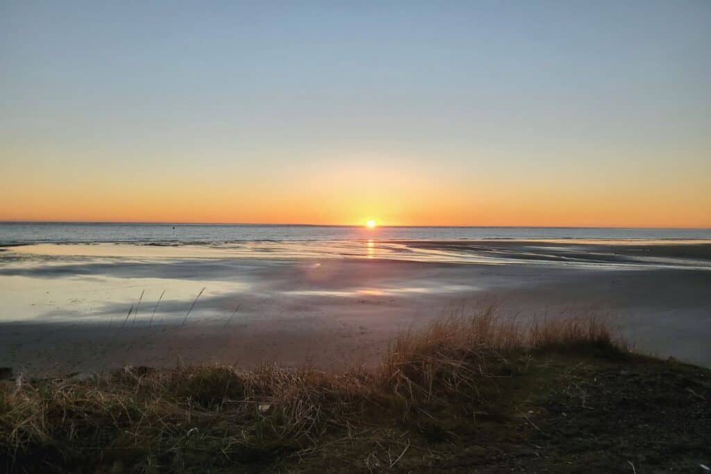 Sunset over Washaway Beach in North Cove Washington with calm shoreline and coastal grasses along the Washington Coast