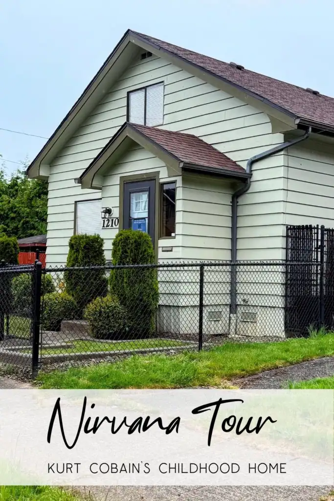 Kurt Cobain Childhood Family Home Exterior 2026 The exterior of Kurt Cobain's childhood family home with light green siding and a chain-link fence at 1210 East First Street in Aberdeen Washington.