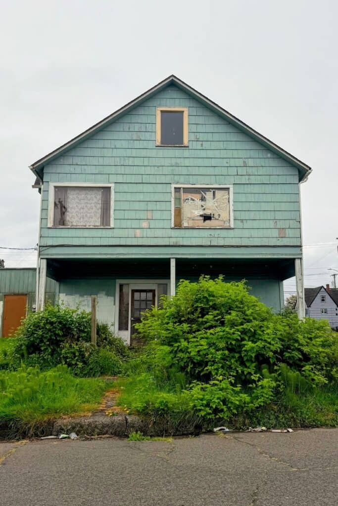 Abandoned historic home in Aberdeen Washington Weathered abandoned house with overgrown yard in Aberdeen, Washington.