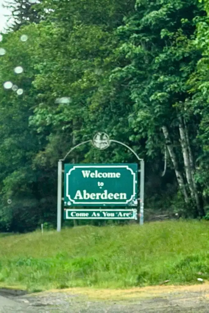 Nirvana's 'Come As You Are' Welcome Sign in Aberdeen WA Welcome to Aberdeen Washington official green city limits sign featuring the Nirvana lyrics Come As You Are against a backdrop of trees.
