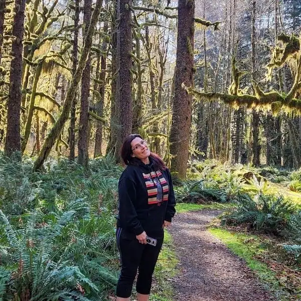 Midlife woman standing on a forest trail in the Pacific Northwest