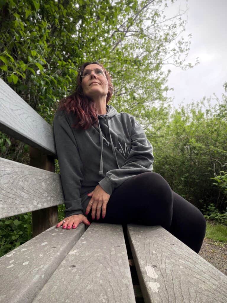 Quiet reflection at Ocosta-by-the-Sea wetlands Woman sitting quietly on a wooden bench near the Ocosta wetlands in Washington during a solo coastal trip.