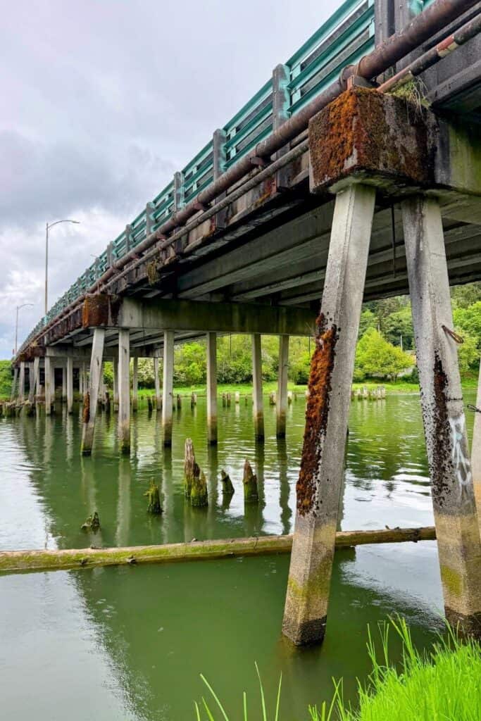 Weathered bridge and pilings in Aberdeen Washington Weathered bridge pilings and moss-covered supports along the river in Aberdeen, Washington beneath cloudy coastal skies.