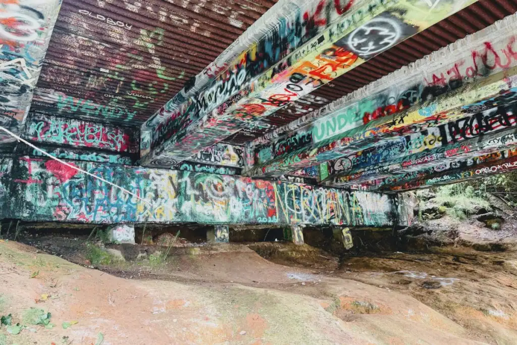 Under the Young Street Bridge in Aberdeen WA The concrete underside of the Young Street Bridge in Aberdeen Washington completely covered in vibrant fan graffiti and rock music tributes.