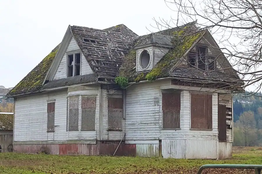 Weathered abandoned house with a mossy roof in Washington State