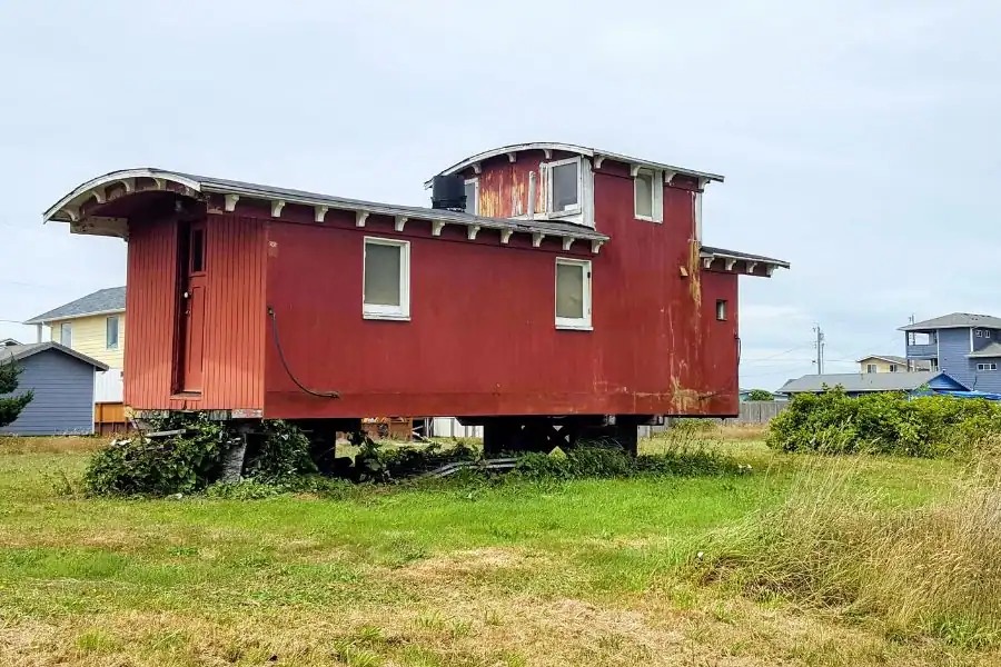 Historic red railroad car on Railroad Avenue in Moclips before being moved to the Museum of the North Beach.