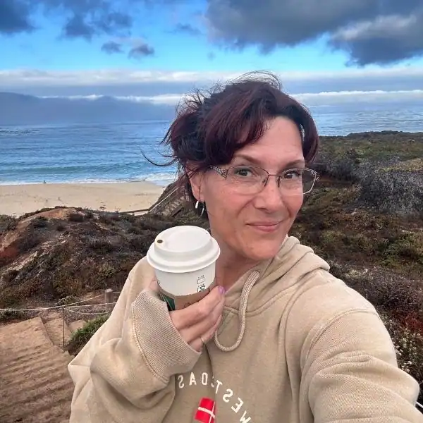 Mandy from PNW Travel Girl holding coffee on a solo birthday trip along the Big Sur coast