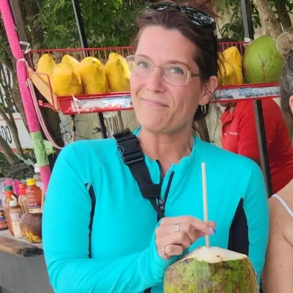 Mandy from PNW Travel Girl drinking from a coconut during an all-inclusive trip in Cancun