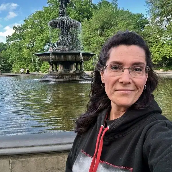 Mandy from PNW Travel Girl on a solo trip to New York City near a park fountain