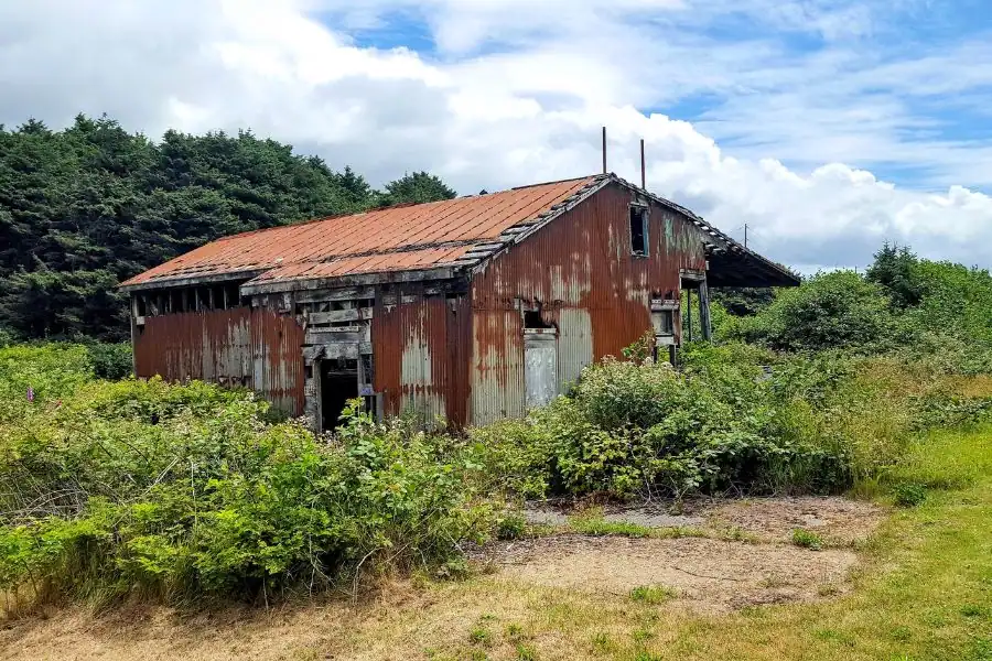 Weathered historic building surrounded by coastal greenery in Moclips, Washington.