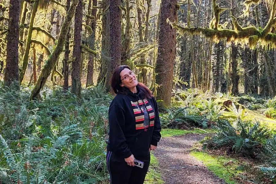 
Midlife woman standing on a forest trail in the Pacific Northwest