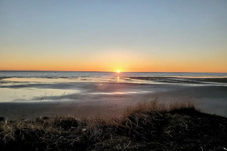 Sunset over the ocean and wet sand at Pacific Beach, Washington