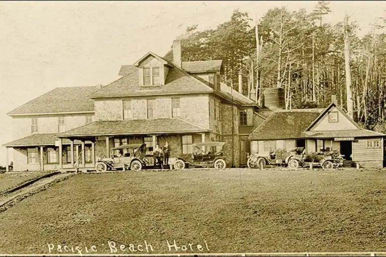 Historic Pacific Beach Hotel with early automobiles parked outside