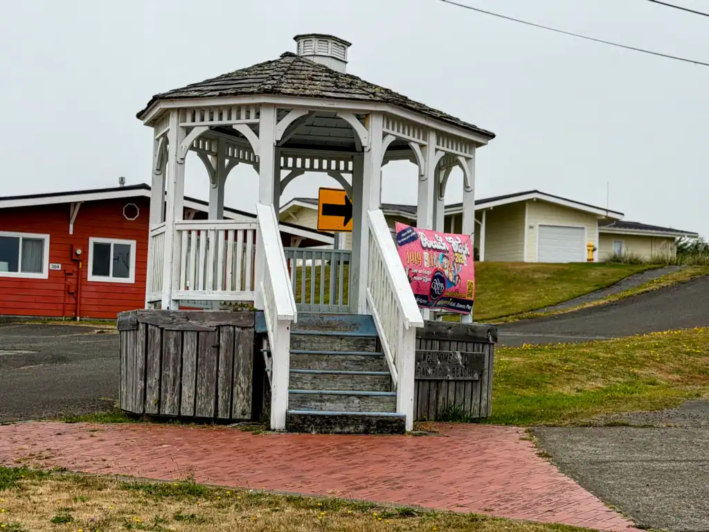 Pacific Beach gazebo in the town’s weathered coastal setting White wooden gazebo in Pacific Beach, Washington with older coastal buildings nearby