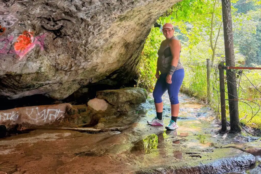 Behind the waterfall at Green River Gorge Woman standing beneath a sandstone overhang behind the waterfall at Green River Gorge