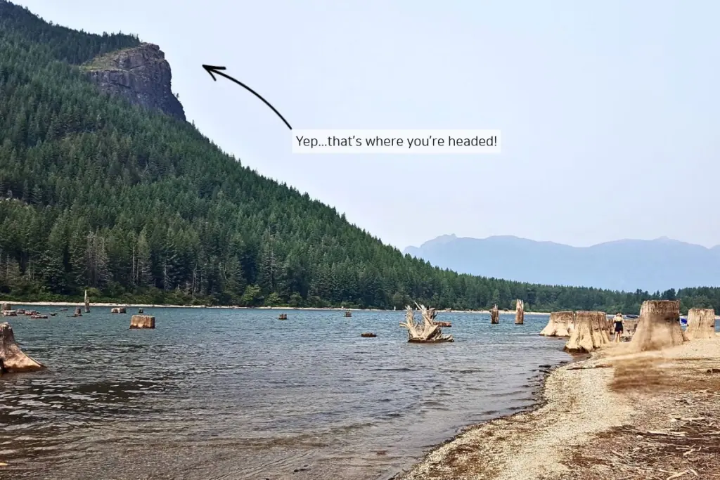 View of Rattlesnake Ledge rising above Rattlesnake Lake near North Bend, Washington, with an arrow pointing to the rocky hiking destination.
